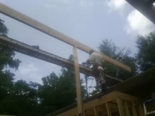Carpenter setting a ridge beam over a new addition frame — Ice Dam Removal by Roofing Brothers in Macedon