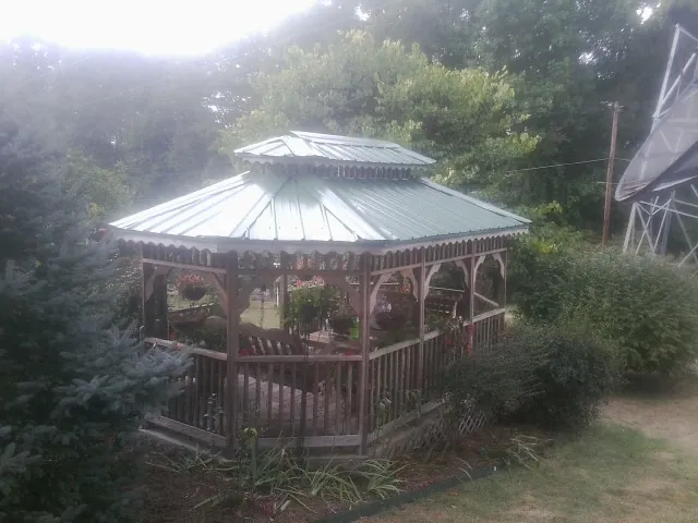 Green metal roof on a backyard gazebo surrounded by garden beds in Macedon